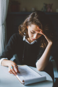 a woman sitting at a table reading a book